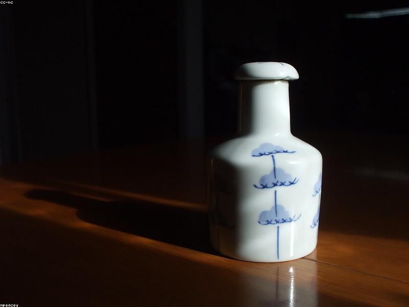 Bottles and bowls of different types of soy sauce arranged on a wooden surface